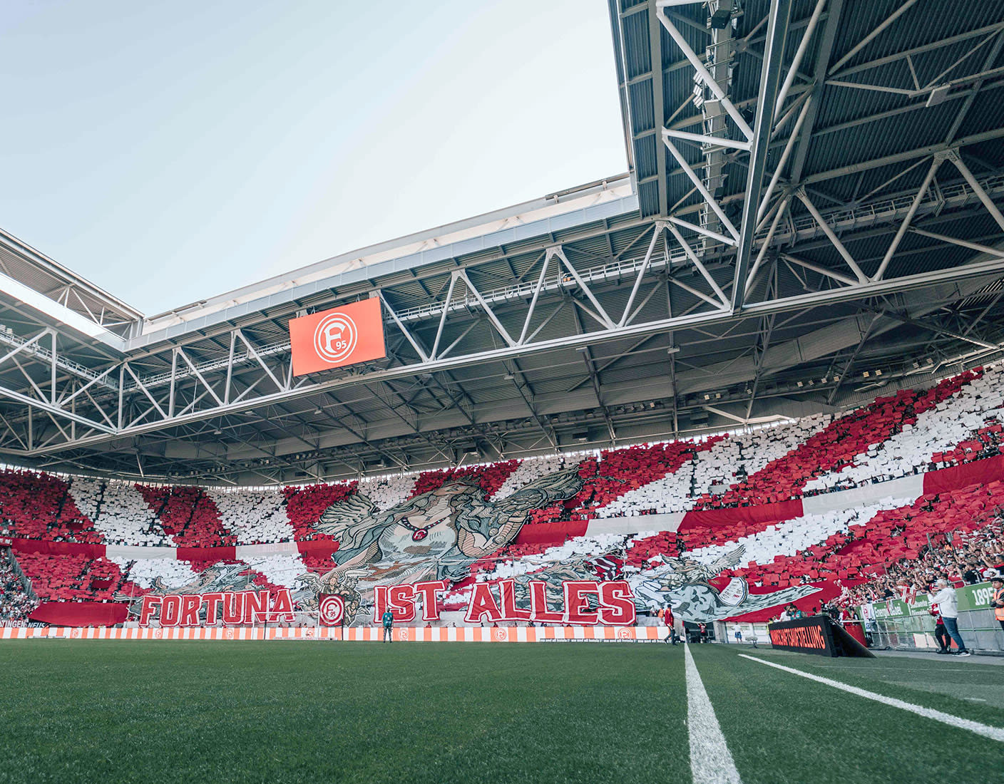 Ein Fortuna-Fußballstadion mit einem auffälligen rot-weißen Banner, das über die Tribünen gespannt ist.